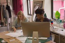 Fashion designers working on desk in fashion studio — Stock Photo