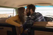 Romantic couple kissing in vehicle on road trip — Stock Photo