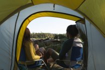 Rear view of couple relaxing near tent in the forest — Stock Photo