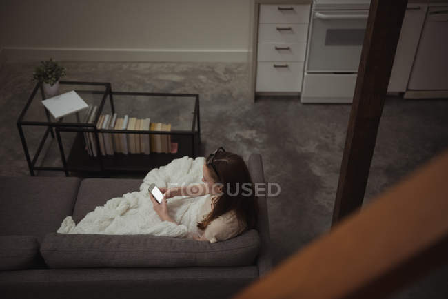 High angle view of woman using mobile phone on sofa at home — Stock Photo