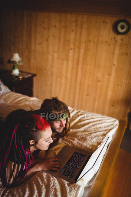 High angle view of young hipster couple using laptop on bed at home — Stock Photo