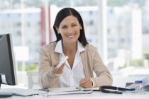 Portrait of a smiling receptionist sitting in hospital office — Stock Photo