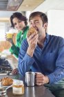 Couple having breakfast at kitchen counter — Stock Photo