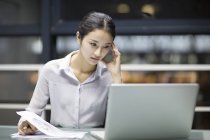 Tired Chinese businesswoman working late in office — Stock Photo