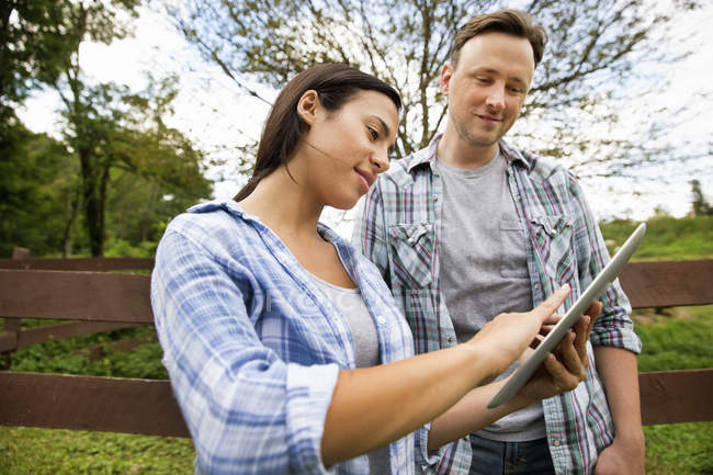 Uomo e donna che utilizzano tablet digitale in azienda biologica . — Foto stock