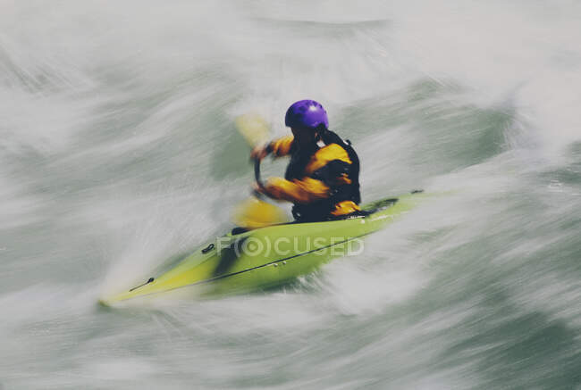 Whitewater kayaker paddling large river rapids on a fast flowing river — Stock Photo