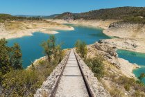 View to small railroad leading to blue lake in mountains. — Stock Photo