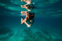 Anonymous boy snorkeling in sea water — Stock Photo