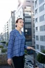 Side view of pretty female manager in checkered shirt smiling and looking away — Stock Photo