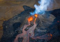 From above magma sparks out of the volcano hole and run like rivers of lava over the ground in Iceland — Stock Photo