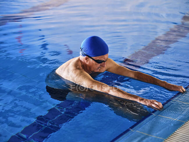 Maturo uomo in cuffia in piedi in piscina durante acqua aerobica classe — Foto stock