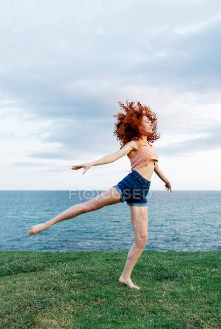 Corpo pieno di danza femminile scalza sulla costa del mare increspato — Foto stock