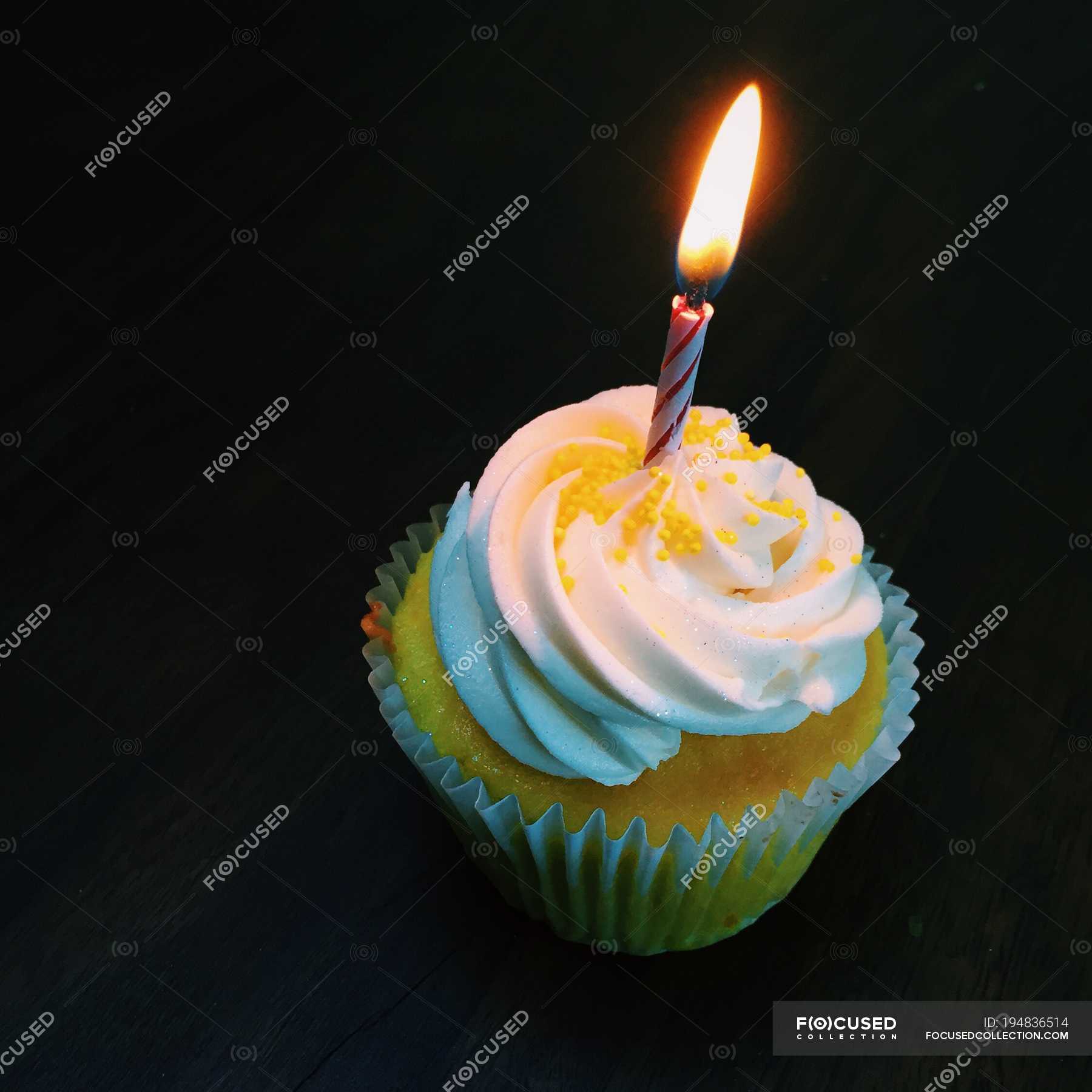 Cupcake with a lonely candle against black background — copy space, nobody  - Stock Photo | #194836514