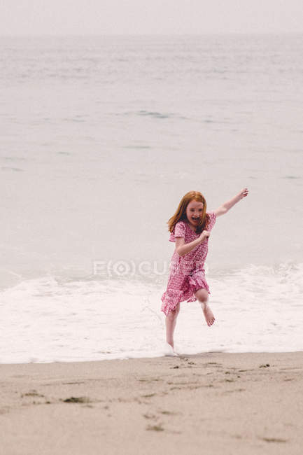 Ragazza che fugge dalle onde — Foto stock