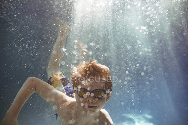 Primo piano di un ragazzo che nuota sott'acqua in una piscina — Foto stock