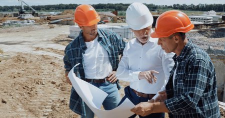 Foto de Ingeniero y constructores discutiendo el proyecto en el sitio de construcción - Imagen libre de derechos