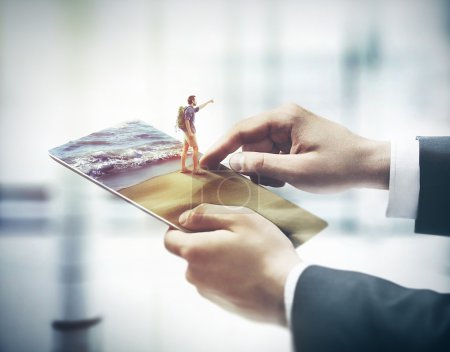 Foto de Las manos del hombre de negocios sostienen la tableta PC, buscar en lugares de exhibición para viajar en la playa de arena con guía - Imagen libre de derechos