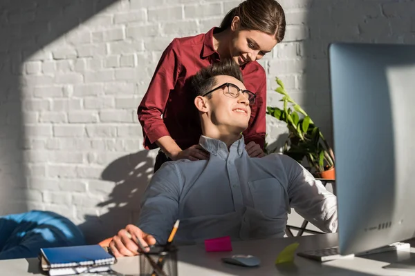 businessman recieving massage from his girlfriend at workplace