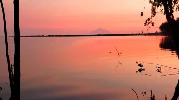 The lake reflects red light at sunset. Red lake at sunset.