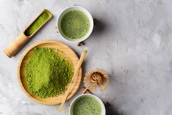 Matcha green powder and tea on gray concrete background