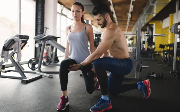 trainer assisting woman lose weight