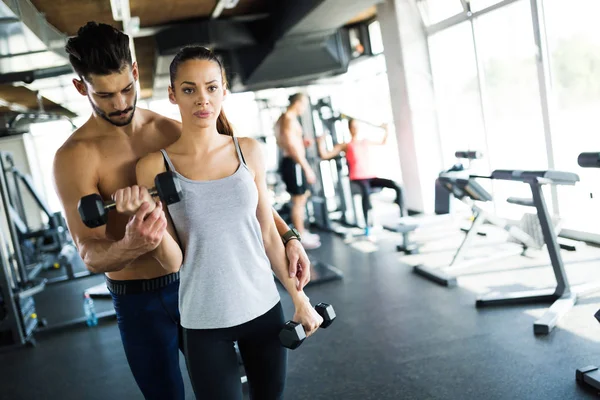 trainer assisting woman lose weight