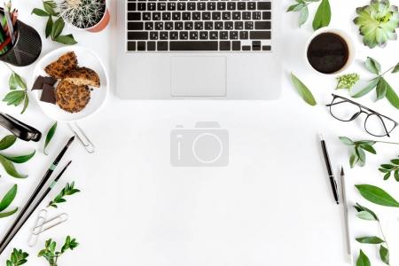 Foto de Vista superior de la computadora portátil, suministros de oficina y taza de café en el lugar de trabajo aislado en blanco, concepto de comunicación inalámbrica - Imagen libre de derechos