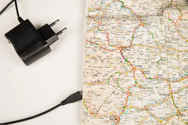 Paper map with USB cable, analog vs. digital concept.