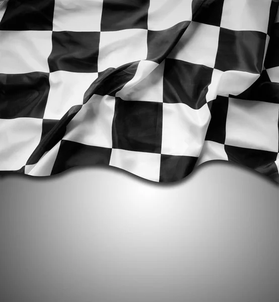 Checkered black and white flag on grey background. Copy space