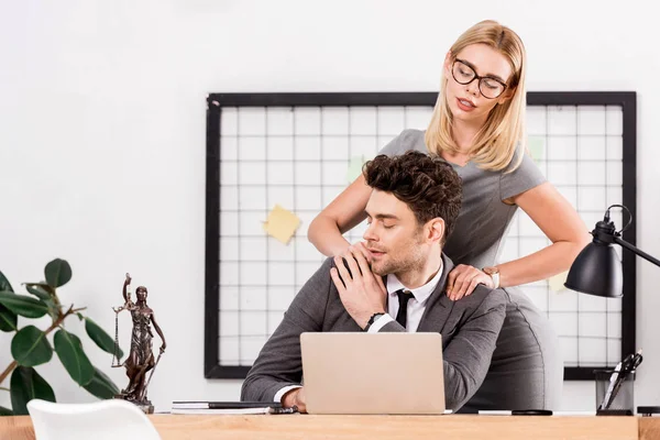 businesswoman making massage to colleague at workplace in office, office romance concept