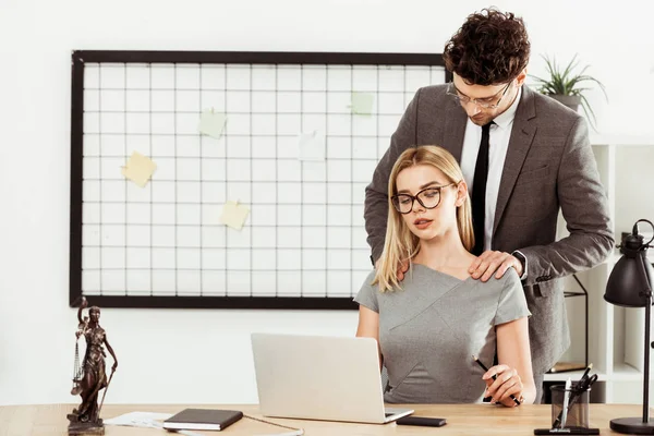 male lawyer making massage to colleague at workplace in office, flirt concept