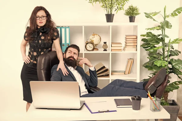 Lazy boss office. Offer massage. Man bearded hipster boss sit in leather armchair office interior. Boss and secretary girl at workplace. Relations at work. Business people and staff concept