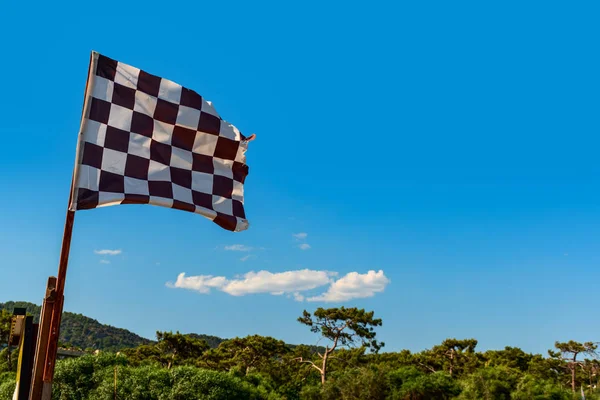 black white checkered wind flag on tropical beach