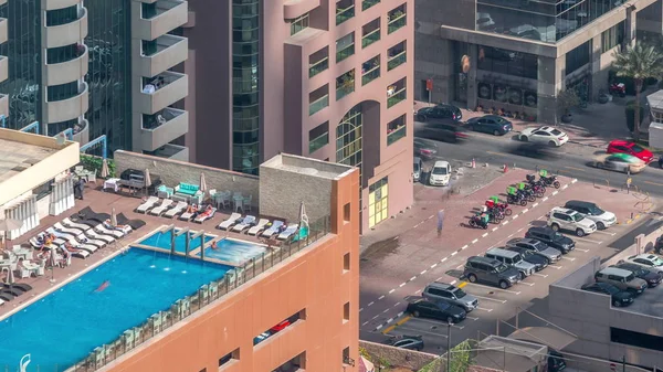 Car parking lot with rooftop swimming pool viewed from above timelapse, Aerial top view. Dubai, UAE