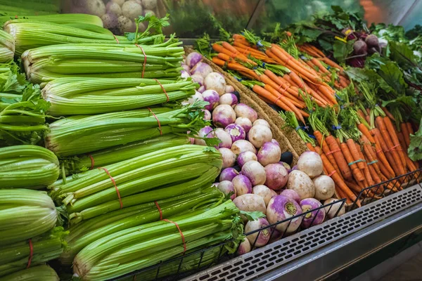 Lots of Vegetables in the Produce aisle at a Supermarket. Colorful counter with large assortment of fresh vegetables for sale in eco products store, vegetable zone. Nobody, selective focus.