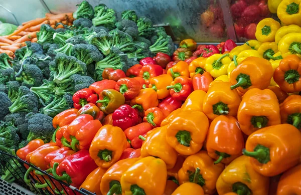 Lots of Vegetables in the Produce aisle at a Supermarket. Colorful counter with large assortment of fresh vegetables for sale in eco products store, vegetable zone. Nobody, selective focus.