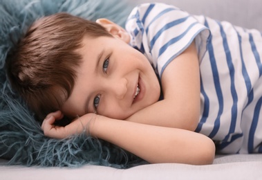 Photo of Cute little boy lying on sofa, closeup