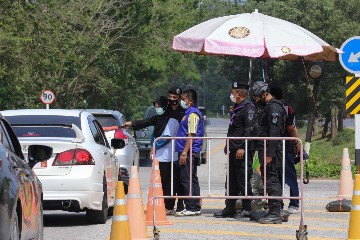 Officials inspect motorists at a provincial border checkpoint between the southern provinces of Pattani and Narathiwat as a preventive measure against Covid-19. AFP