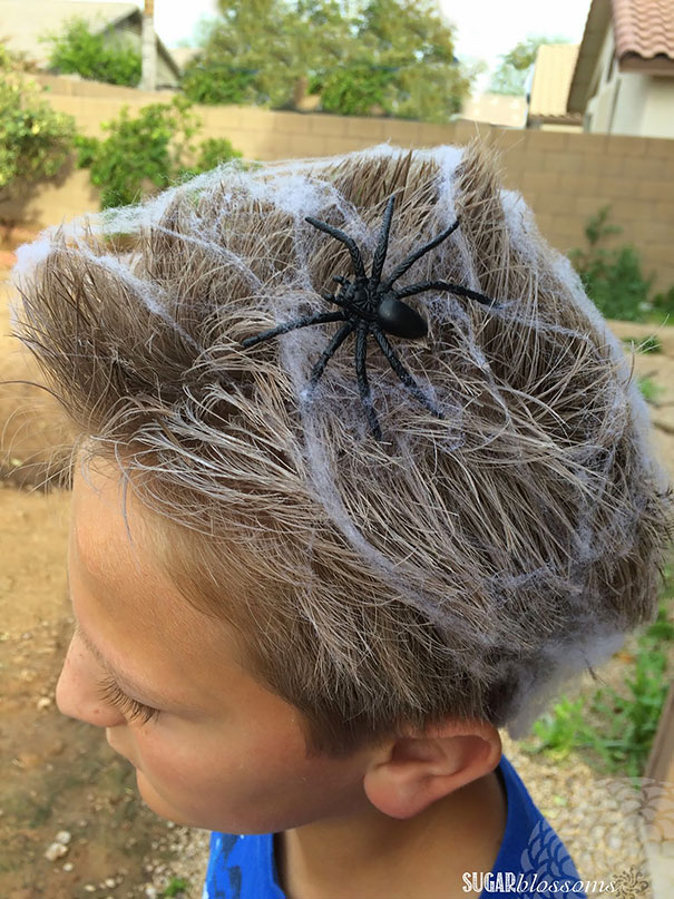 Child with crazy hair day style featuring a spider and webs.