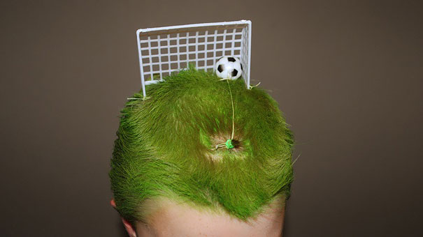 Creative crazy hair day style with green grass-like hair and toy soccer goal.