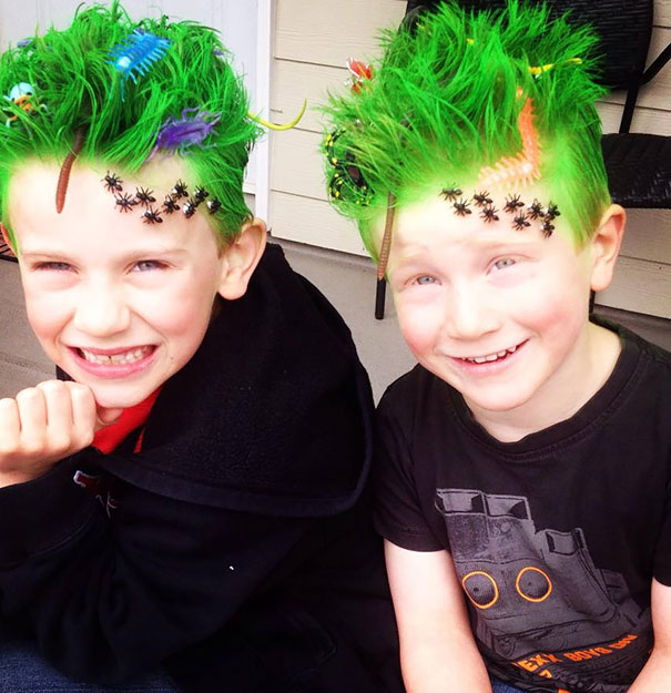 Two kids with crazy green hair decorated with toy insects and combs.