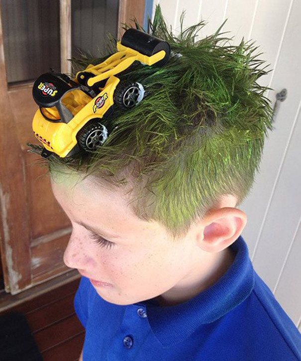 Boy with green hair styled with toy bulldozer for crazy hair day.