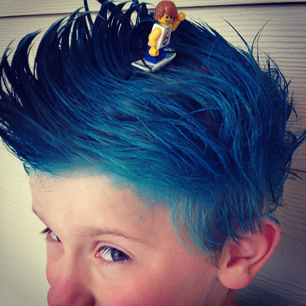 Blue spiky hair styled creatively with a miniature skateboarder toy, showcasing a fun Crazy Hair Day idea.