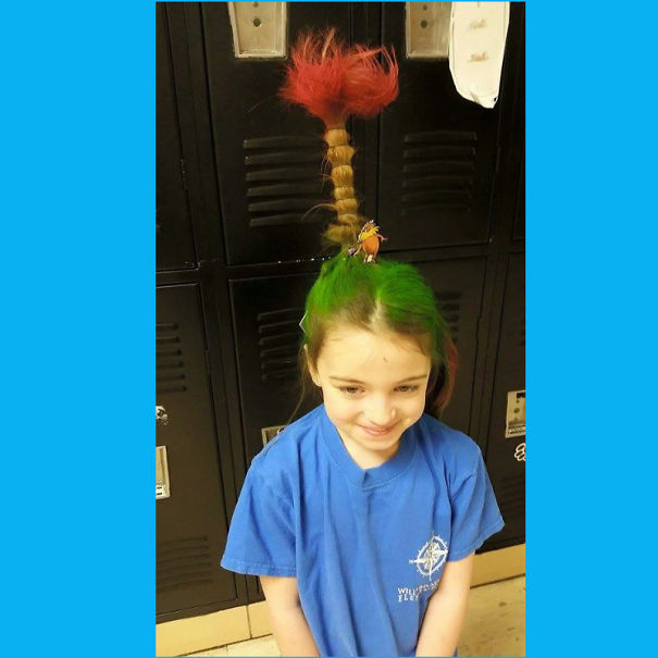 Child with a crazy hair day style: green and red braided hair standing upright.