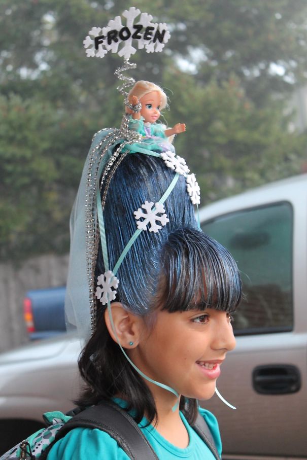 Girl with an elaborate Frozen-themed crazy hair day hairstyle featuring snowflakes and a doll.