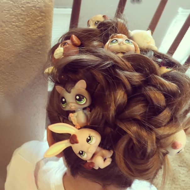 Crazy Hair Day hairstyle featuring toy animals intertwined in curly brown hair.