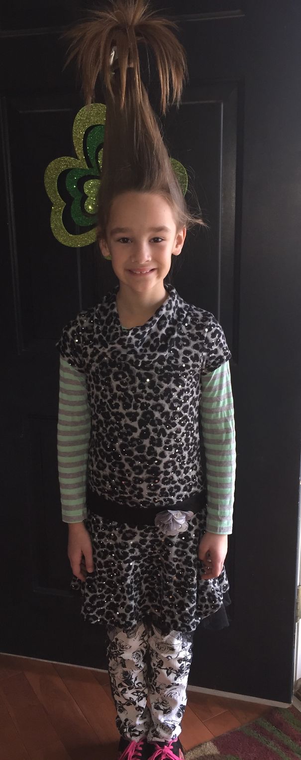 Child with a tall, spiky hairstyle for Crazy Hair Day, wearing a leopard print outfit and striped sleeves.