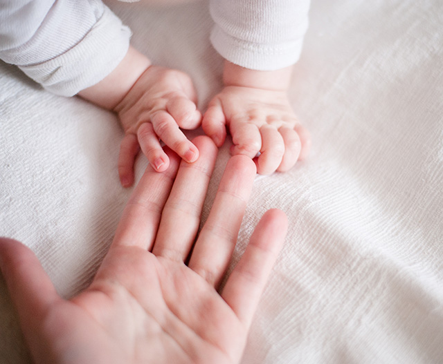 woman holding baby chewing toy