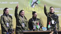 Israeli female soldier hostages wave before being handed over to the Red Cross in Gaza City, Saturday, Jan. 25, 2025. (AP Photo/Abed Hajjar)