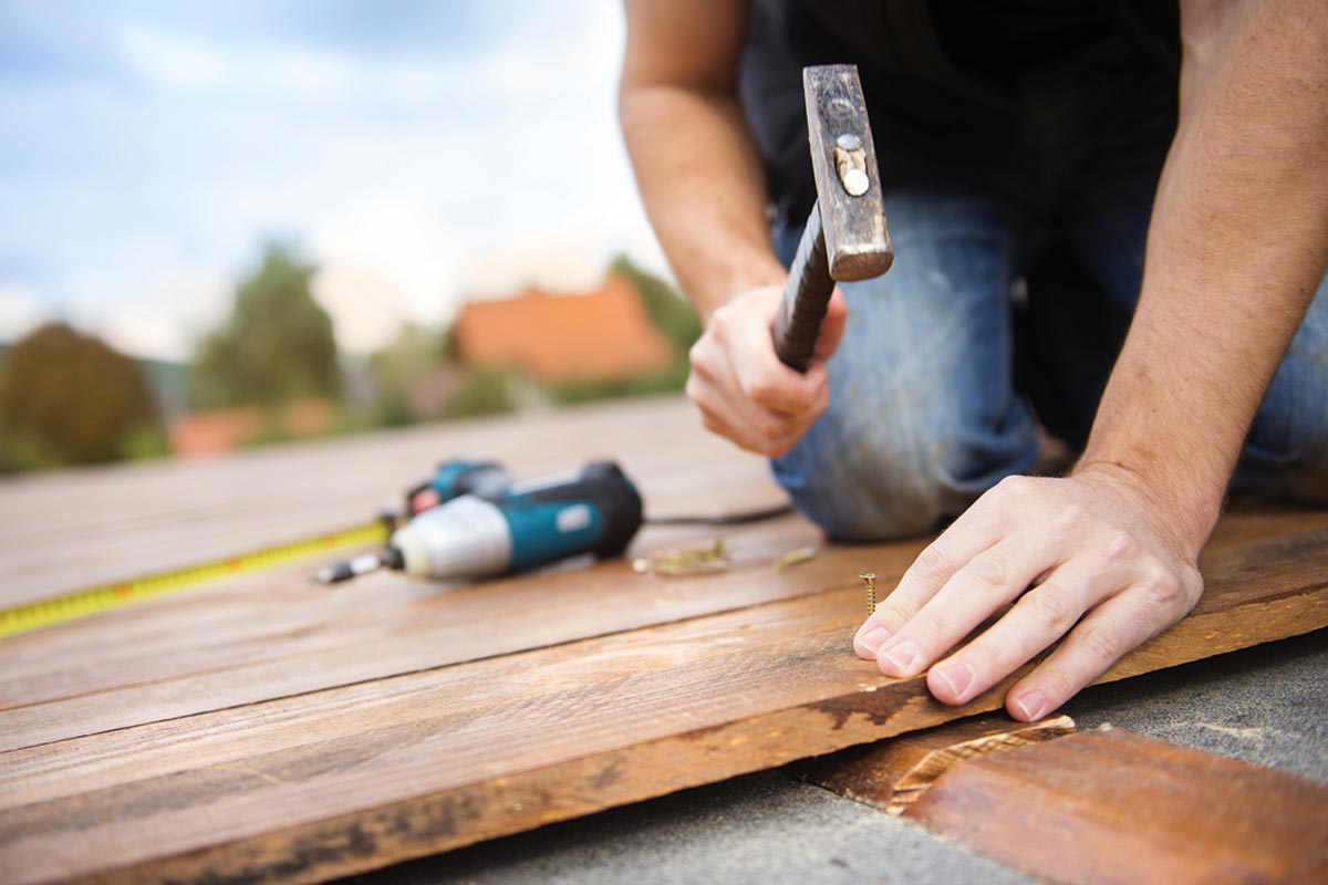 Self employed handyman repairing a deck